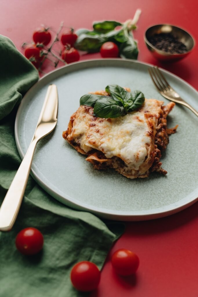 A savory serving of Italian lasagna garnished with fresh basil leaves on a stylish plate.